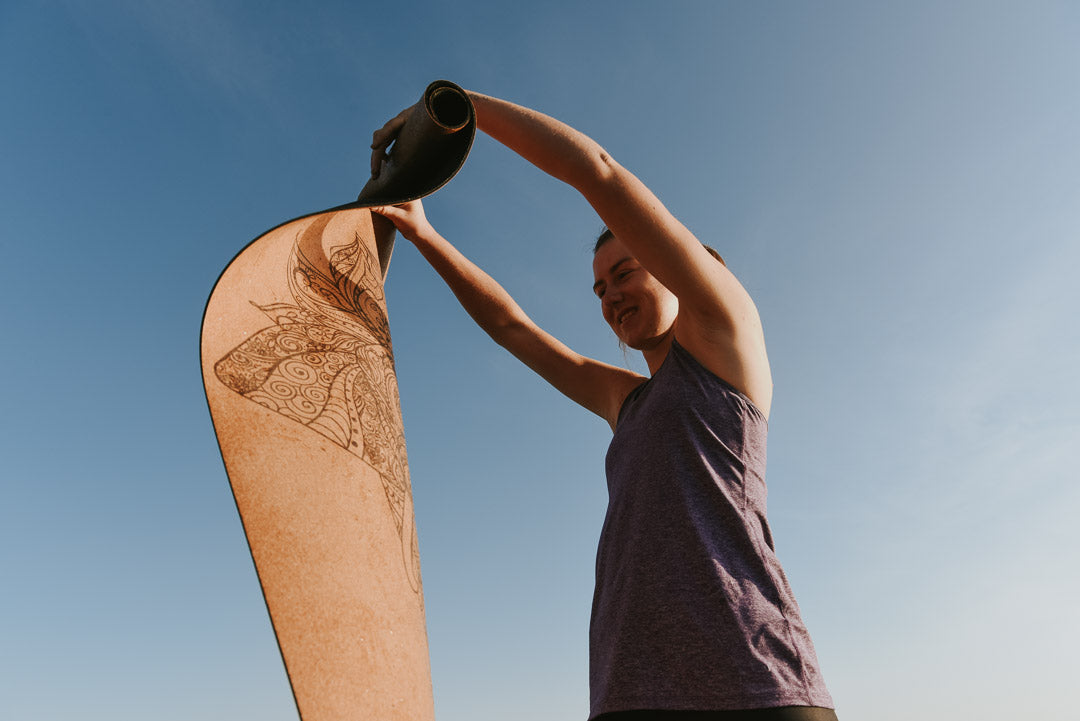 Woman rolling up cork yoga mat