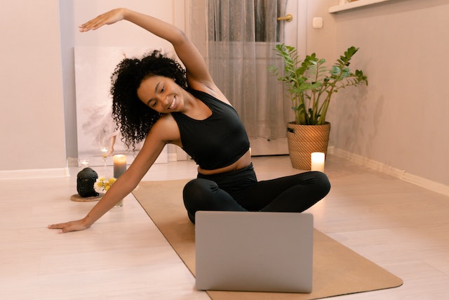 Woman attending a yoga class on her laptop