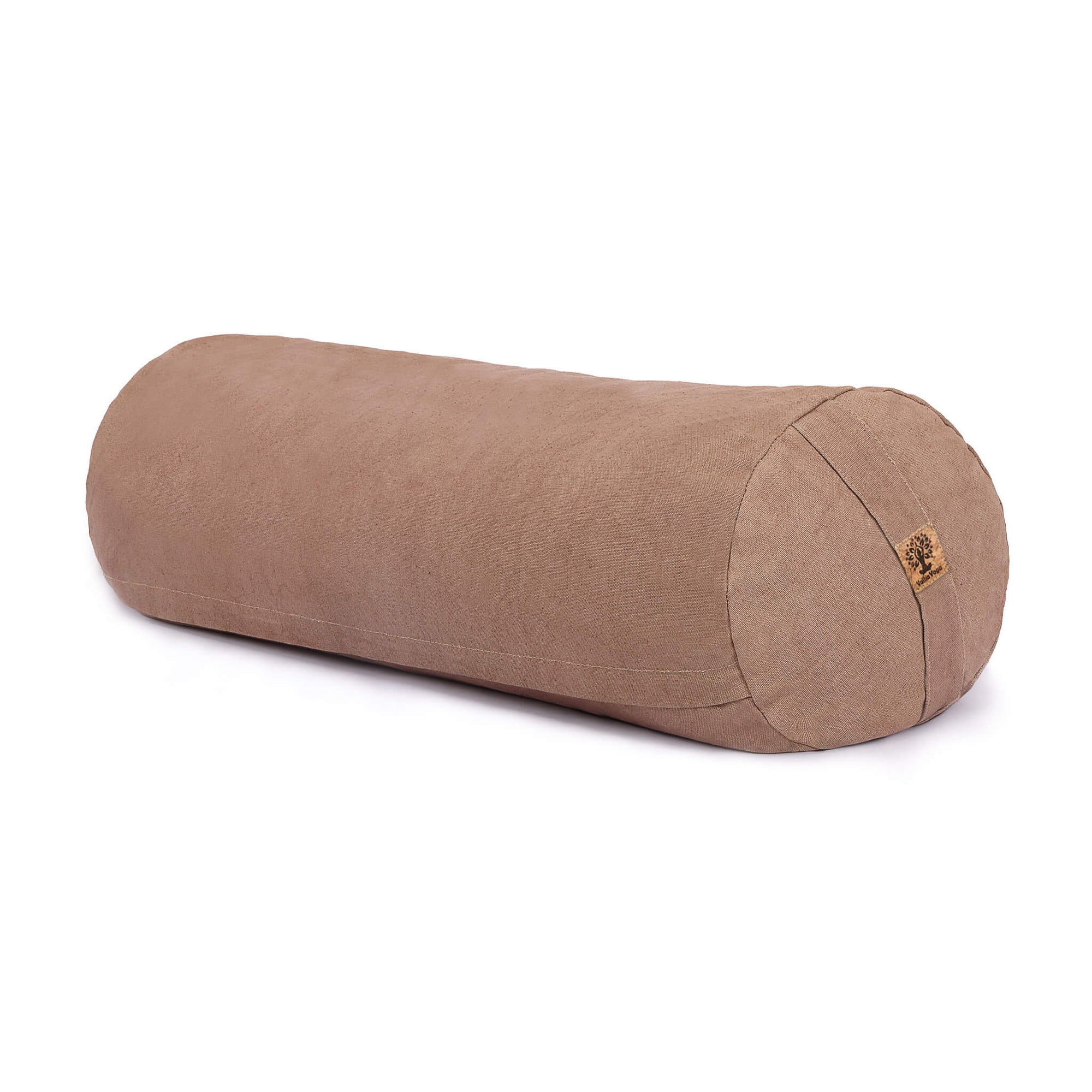 A cylindrical bolster pillow in a warm beige / brown colour, made of textured fabric, shown on a clean white background with a small cork tag on one end