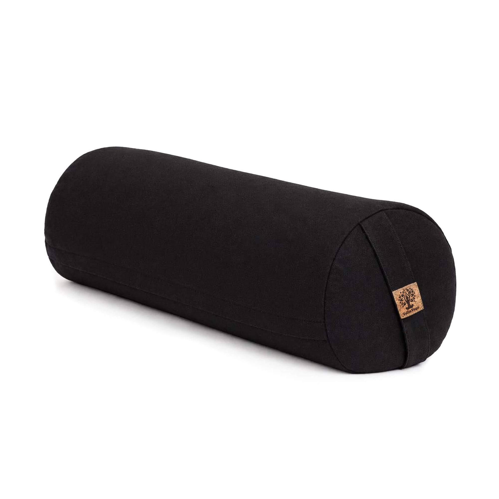 A black cylindrical yoga bolster pillow with a small cork patch on the end, shown on a clean white background